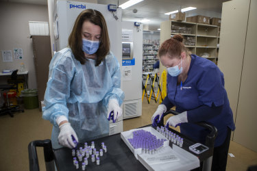 Nicole Dirnbauer of the Monash Medical Centre opens the Pfizer vaccine.