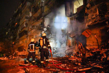 Firefighters inspect the damage at a building following a rocket attack on the city of Kyiv, Ukraine.