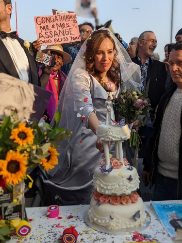Stella Moris cuts her wedding cake outside Belmarsh Prison.