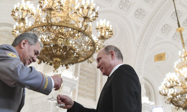 Defence Minister  Sergei Shoigu - seen here toasting President Vladimir Putin - was guest of honour. 