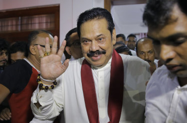 Newly appointed Sri Lankan Prime Minister Mahinda Rajapaksa leaves a Buddhist temple after meeting his supporters in Colombo.