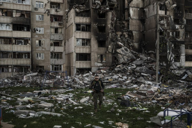 Ukraynalı bir asker, Ukrayna'nın Kharkiv kentinde bir cephe hattının yakınında çok sayıda Rus bombardımanında ağır hasar gören bir binanın enkazının arasında yürüyor.