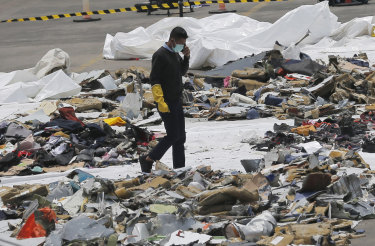 An investigator walks amid debris of Lion Air Flight 610 retrieved from the waters off Tanjung Priok in Jakarta.