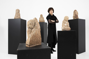 Worn, humble and powerful: Powerhouse curator Min-Jung Kim with some of the stone Arhats statues from South Korea.