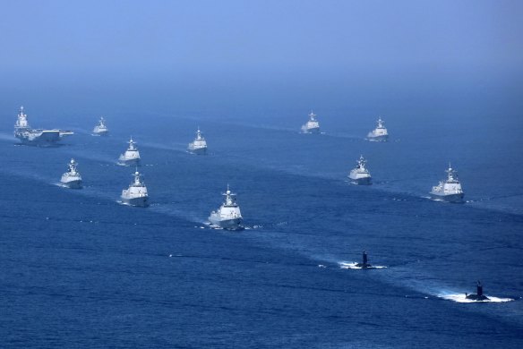 Chinas's Liaoning aircraft carrier is accompanied by navy frigates and submarines conducting exercises in the South China Sea. 