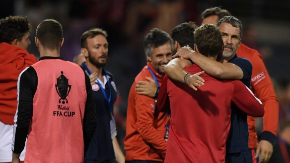 Off to the final: Adelaide coach Marco Kurz (right) celebrates with his players after victory over the Wanderers.