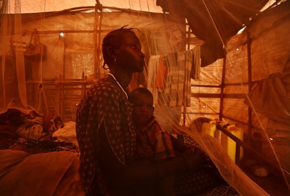 Sexual violence survivor Chol Wechtuo 36 holds her son Dakhoa Gatluak which translates to 'destruction of the world', inside their makeshift home in the UN Juba Protection of Civilian's site. During the civil war Chol survived a multiple gang rape attack when she went outside the PoC to retrieve her buried money. Her son is the result of this gang rape.