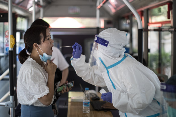 A medical worker takes samples during a mass COVID-19 test in a residential block in Wuhan.