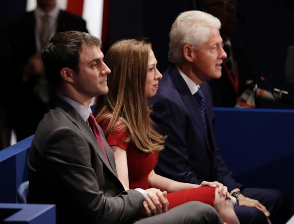 Bill Clinton sits with his daughter Chelsea and her husband Marc Mezvinsky.