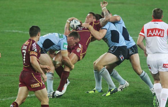 Corey Parker tackled by hard NSW defence.
