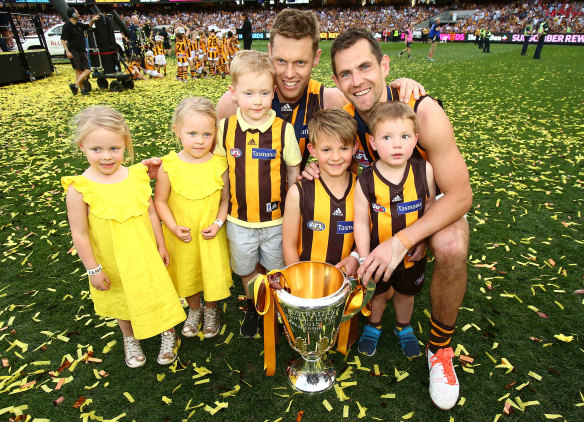 Happy families: Sam Mitchell and Luke Hodge celebrate their 2015 premiership with their kids on the MCG.