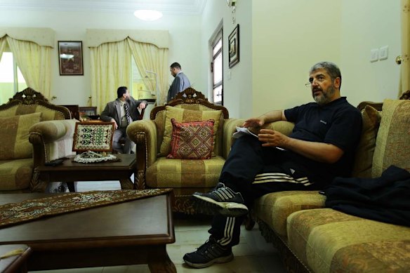 Khalid Mishal (right) reads briefing notes at a friend's house in Doha, Qatar.