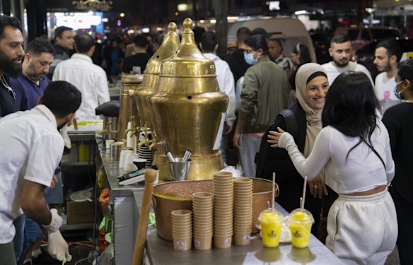 Woman chat at a drink stall in Haldon Street.