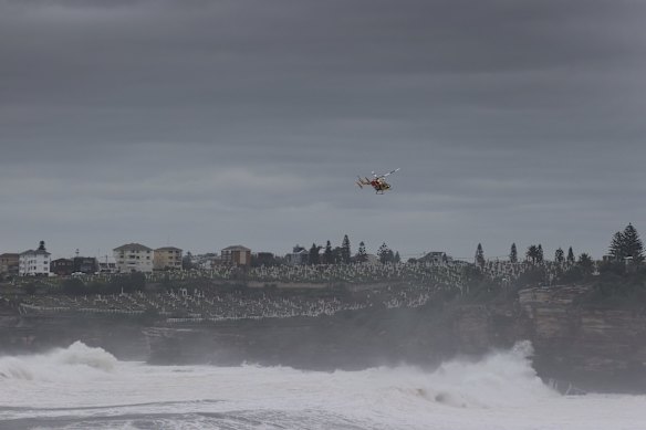 Search crews look for survivors as a small aluminium boat sinks offshore in the big swell at Bondi Beach. Police later confirmed the owner was safe and well, and had last seen his boat moored at Gordons Bay.
