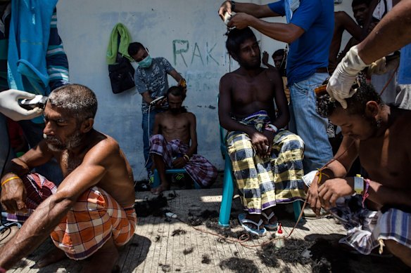 KUALA LANGSA, INDONESIA - MAY 19:  Volunteers help Bangladeshi migrants cut their hair at a temporary shelter on May 19, 2015 in Kuala Langsa, Aceh province, Indonesia. Hundreds of Myanmar's Rohingya refugees arrived in Indonesia on May 15, many requiring medical attention. Thousands more are believed to still be stranded at sea reportedly with no country in the region willing to take them in. Myanmar's Rohingya Muslim community have long been persecuted and marginalized by Myanmar's mostly Buddhist population. 
