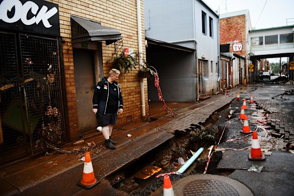 The owner of Flock Espresso and Eats, Sarah Jones, inspects the damage at the back of the business, which was devastated by the flood.