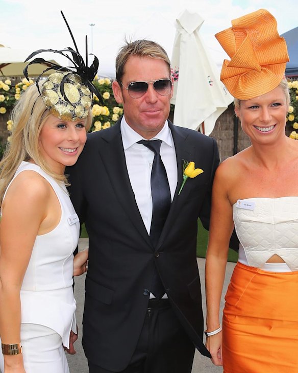 Shane Warne talks to two racegoers as he attends on Melbourne Cup Day at Flemington Racecourse on November 4, 2014 in Melbourne, Australia. 