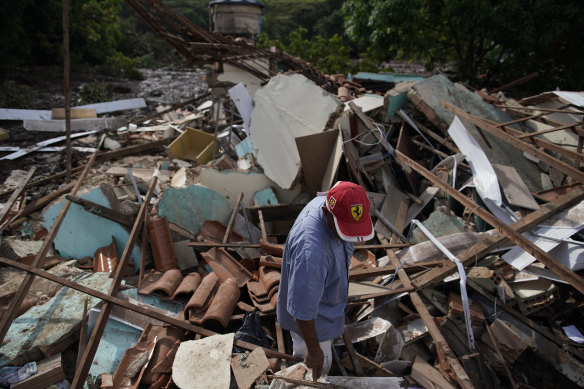 A man stands in the debris of his home that was destroyed after the collapse. 