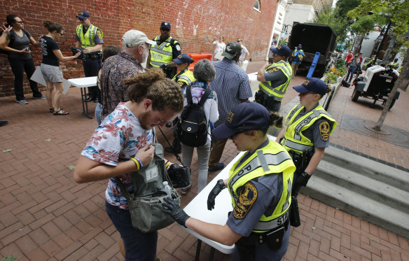 Police inspect bags as they lock down the downtown area in anticipation of the anniversary of last year's Unite the Right rally in Charlottesville.
