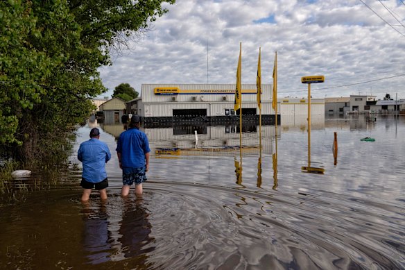 Workers inspect flooded businesses on the Newell Highway, Saturday November 5, 2022.