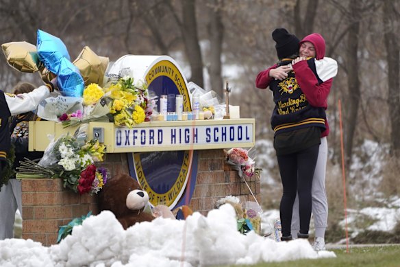 Students hug at a memorial at Oxford High School in Oxford, Michigan, Wednesday, December 1, 2021. Authorities say a 15-year-old sophomore opened fire at Oxford High School, killing four students and wounding seven other people.