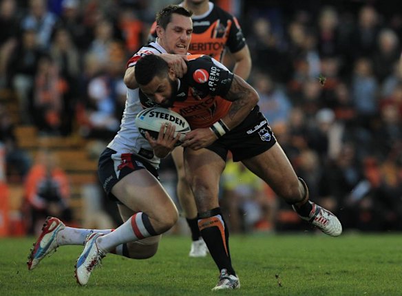 The Roosters' Mitchell Pearce tackles the Tigers' Benji Marshall.