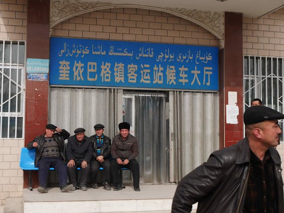 Uighurs wait outside a bus station in Kuybagh town, Poskam County.
