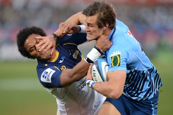 JJ Engelbrecht of the Bulls hands off Henry Speight of the Brumbies to score a try.