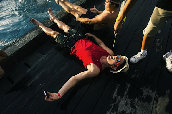 Schoolies lying in a line on the floor next to the pool and getting Midori poured in their mouths at the Skypool Hotel in Legian, 2014.