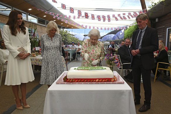 Britain's Queen Elizabeth II , centre, Camilla, the Duchess of Cornwall, centre left and Kate, the Duchess of Cambridge, stand with Board director of Eden Project, Peter Stewart as the Queen cuts a cake as they  attend an event in celebration of 'The Big Lunch 'initiative, during the G7 summit in Cornwall, England, Friday June 11, 2021. 