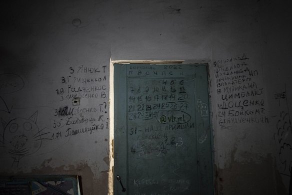 Names of the dead cover a wall and a door in the basement of a school in Yahidne, near Chernihiv, where more than 300 people were trapped for weeks by Russian occupiers.