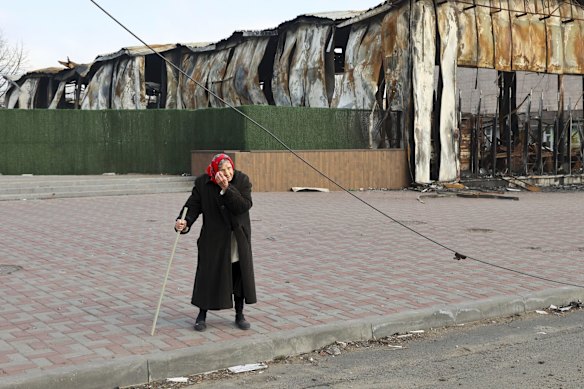 An elderly local resident stands behind a destroyed part of the Illich Iron &  Steel Works Metallurgical Plant, the second largest metallurgical enterprise in Ukraine, in an area controlled by Russian-backed separatist forces in Mariupol, Ukraine.