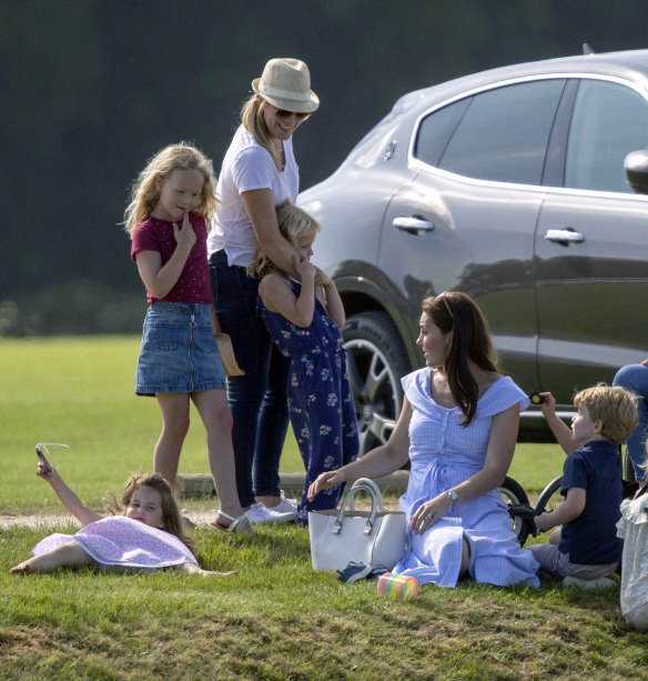 The Duchess of Cambridge, second right, sits with Prince George and Princess Charlotte as she talks to Autumn Phillips and her children, Savannah and Isla, as they watch Prince William take part in a charity polo event on Sunday.