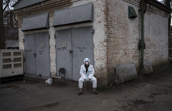 A volunteer rests after loading the corpses of civilians killed by Russian soldiers into a truck in Bucha.