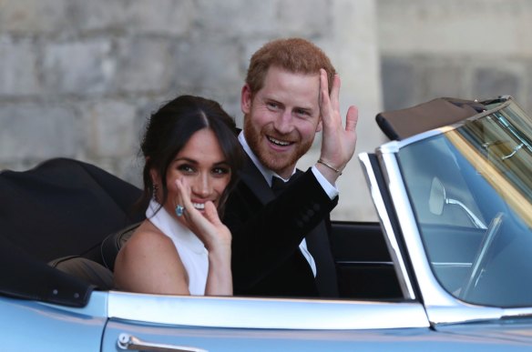 The newly married Meghan Markle and Prince Harry leave Windsor Castle in a convertible after their wedding to attend an evening reception at Frogmore House.