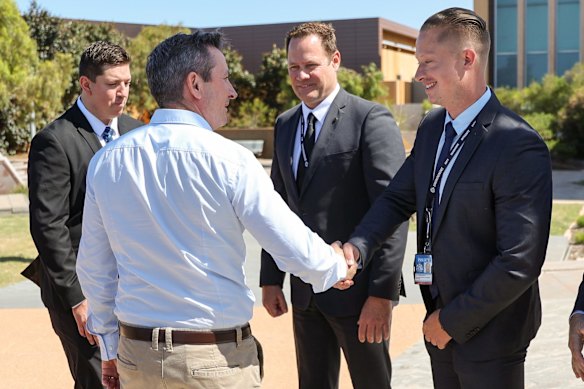 Western Australia Premier Mark McGowan greets police officers as he arrives at a press conference in front of the Carnarvon Police Station.