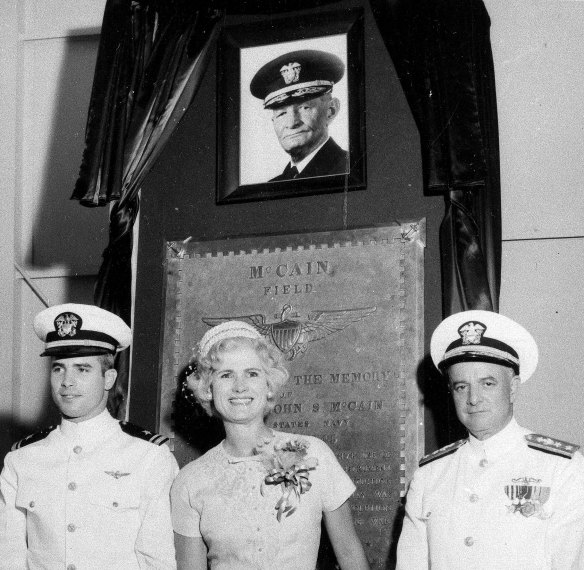 From left, US Navy Lieutenant Commander John McCain III and his parents, Roberta McCain and Rear Admiral John McCain jnr, stand in front of a plaque with an image of his grandfather, Admiral John McCain, at the Naval Air Station Meridian McCain Field in Mississippi, in 1961.