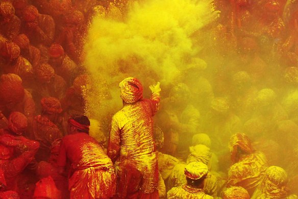 Indian Hindu devotees throw coloured powder at the Radha Rani temple in Barsana, India.