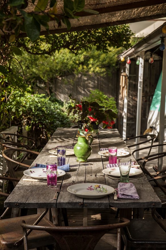 The coloured glasses on the rustic table in the garden are from Rachel and Bryan’s daughter Rosie’s shop, I Am Hawker, in Byron Bay.