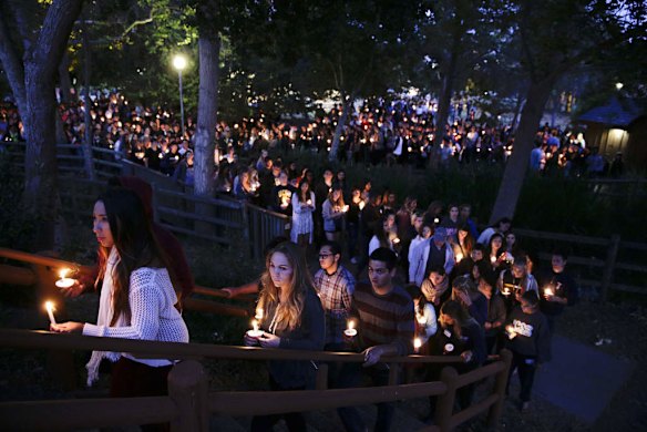 People gather at a park for a candlelight vigil to honor the victims of Friday night's mass shooting on Saturday, in Isla Vista, California.