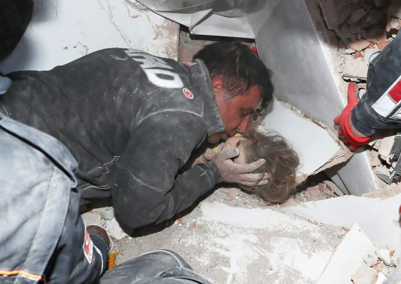 A rescue worker gives Ayda Gezgin as kiss as she's being pulled out alive from the rubble of a collapsed apartment building.