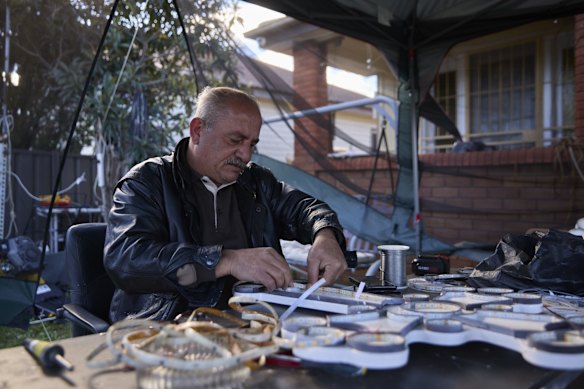 Ramzi, who arrived in Australia from Iraq five years ago, makes crosses in the front yard of his Fairfield home.  An Assyrian Catholic man, Ramzi's father recently passed away, and since lockdown has been making these crosses to keep busy, and as a way to honour and remember his father. 17 July, 2021.