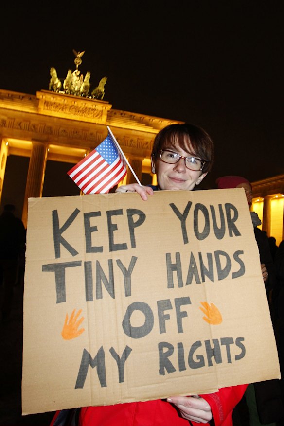 Protesters standing in front of the Brandenburg Gate take part in a gathering to voice their opposition to new U.S. President Donald Trump on the day of his inauguration in Berlin, Germany.