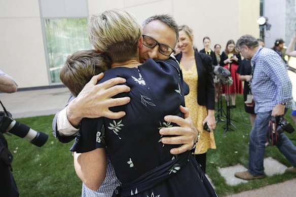 Senator Richard Di Natale embraces his children Luca and Ben and his wife Lucy Quarterman after he addressed the media during a press conference to announce his resignation as leader of the Australian Greens, at Parliament House in Canberra.