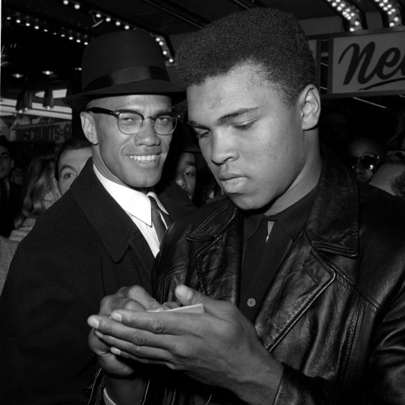 World heavyweight boxing champion Muhammad Ali, right, is shown with black muslim leader Malcolm X outside the Trans-Lux Newsreel Theater in New York, after viewing the screening of a film about Ali's title fight with Sonny Liston, in this March 1, 1964 file photo.