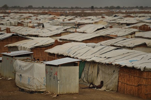 A man lies against the side of one of the thousands of makeshift homes  inside the UN Bentiu Protection of Civilian's site where over 100,000 people live having fled violence and fighting. 