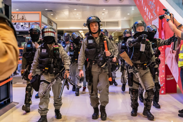 Riot police secure an area during a demonstration in a shopping mall.