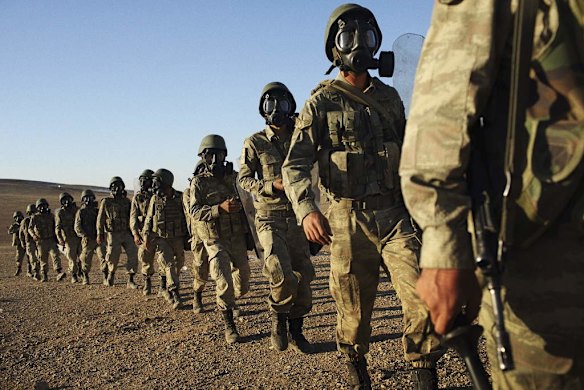 Turkish soldiers secured an area after firing tear gas to disperse a large crowd that had gathered on a rise on the Turkish side of its border with Syria. On the other side of the border fence, just a few hundred metres away, shells and mortars continued to send plumes of smoke into the air above Kobani.