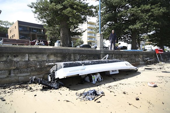 Yachts and damaged boats line the shore of Little Manly Beach on Sydney Harbour.
