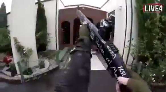 A screenshot from the gunman's chilling video. It shows the gunman holding a high-powered gun outside the mosque.